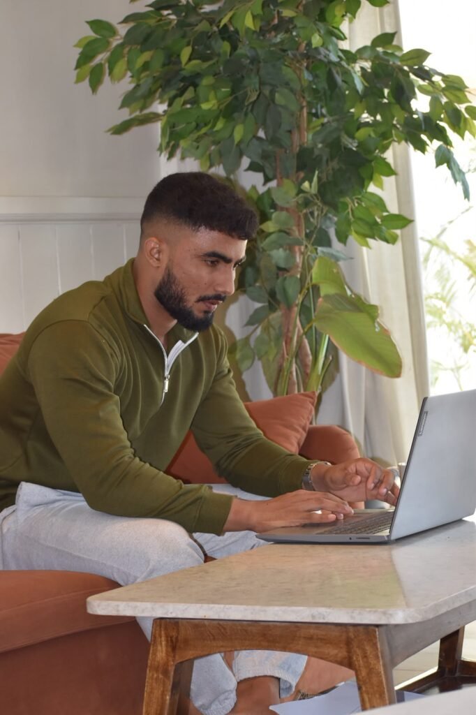Divyansh Singh, founder of DivyanshFit, planning client programmes on his laptop
